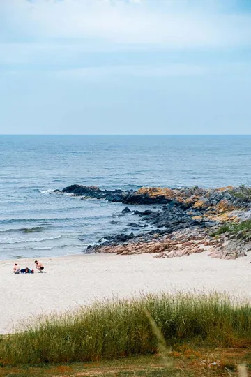 Sandkås strand ligger i en bugt med klipper på hver side