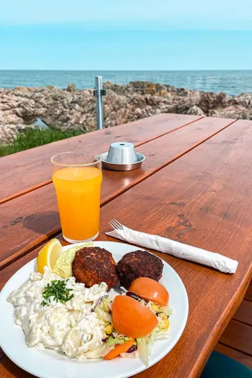 Nyd din frokost med smuk udsigt over klipper og Østersøen hos Nordbornholms Røgeri